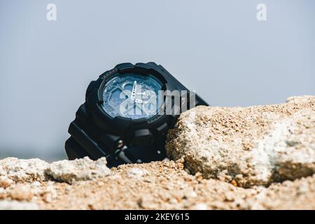 Nahaufnahme einer schwarzen analog-digitalen Hybrid-Sportarmbanduhr. Lässiges Accessoire für Herren. Stockfoto