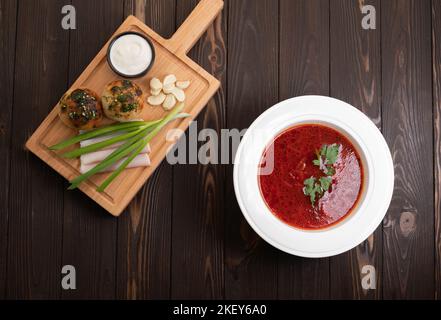 Borscht. Traditionelles ukrainisches Gericht auf einem Teller auf einem hölzernen Hintergrund, Draufsicht Stockfoto