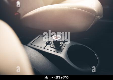 USB-Ladegerät an Zigarettenanzünder im Auto angeschlossen. Stockfoto