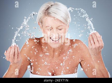 Reife Frau, Wasserspritzer oder Gesichtswaschung in der Hautpflege Routine, morgens Hygiene Wartung oder Gesundheit Wellness. Lächeln, glücklich oder älter Stockfoto
