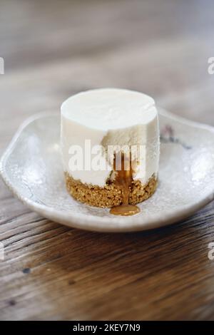 Käsekuchen mit Karamellsauce auf dem Teller. Stockfoto