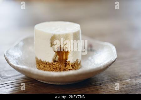 Käsekuchen mit Karamellsauce auf dem Teller. Stockfoto