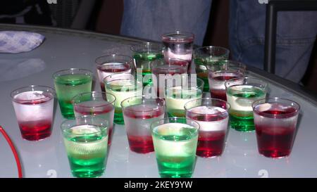 Shot Gläser auf alten Tisch grün rot Wodka Kater Stockfoto