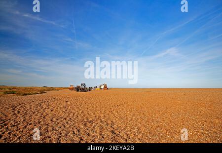 Blick entlang des Kiesstrandes mit Fischerbooten und Ausrüstung westwärts nach Blakeney Point von Cley-Next-the-Sea, Norfolk, England, Vereinigtes Königreich. Stockfoto