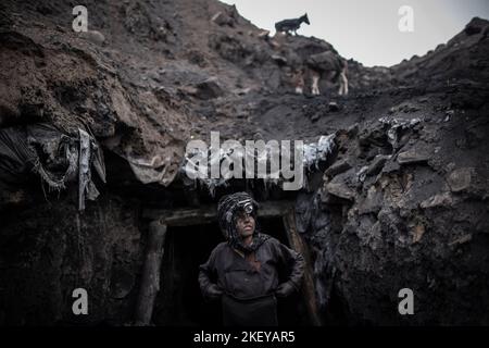 Chinarak, Afghanistan. 12.. November 2022. Ein Junge, der als Bergmann arbeitet, steht vor einer informellen Kohlemine in Chinarak in der afghanischen Provinz Baghlan. Von Männern im Alter von 60s Jahren bis hin zu Jungen im Alter von zehn Jahren arbeiten jeden Tag Hunderte von Bergleuten in den Minen von Chinarak, die mehrere hundert Meter im Berg trugen, für nur ein paar Euro Tageslohn. Die Arbeit ist nicht nur ein Rückfall, sondern auch potenziell tödlich, da kollabierende Minenschächte ein regelmäßiges Auftreten sind. Quelle: Oliver Weiken/dpa/Alamy Live News Stockfoto