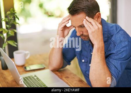 Sein Termin steht bevor... ein Mann, der bei der Arbeit von zu Hause aus Kopfschmerzen hat. Stockfoto