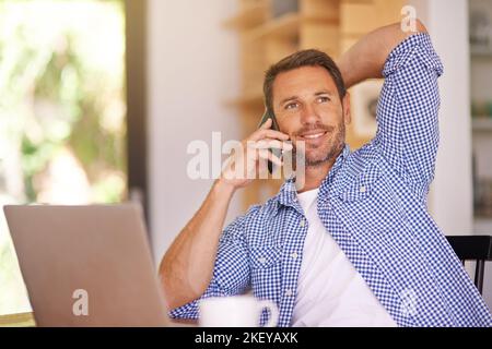 Hes nie zu beschäftigt, um das Telefon zu nehmen. Ein junger Mann von zu Hause aus arbeiten. Stockfoto