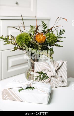 Umweltfreundliche furoshiki Geschenkschachteln mit Wickeltuch. Weihnachtsgeschenke weihnachten Hintergrund mit Furoshiki Geschenkboxen Verpackung in Null Abfall Stil und grün Stockfoto