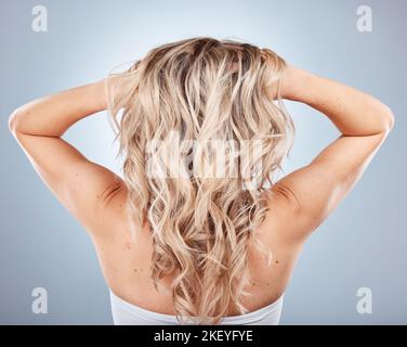 Frauen-, blonde und wellige Haarpflege im grauen Studio-Hintergrund nach Friseursalon Behandlung, Haarschnitt oder Frisur Highlights. Modell, Rücken und Stockfoto