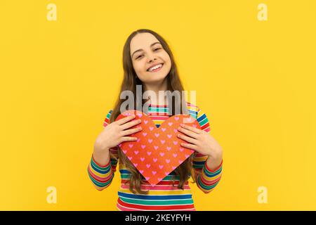 Valentinstag. Träumend niedliches Teenager-Kind mit rotem Herz. Stockfoto