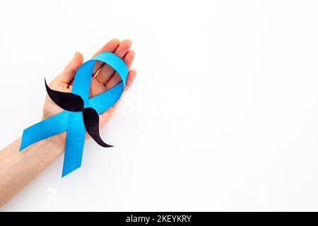 Awareness blaues Band mit einem Schnurrbart aus Papier. Symbol für Prostatakrebs Stockfoto