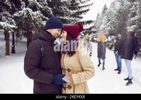 Glückliches Paar in der Liebe verbringen wunderbaren Tag im Winterwald in Gesellschaft von ihren Freunden. Stockfoto