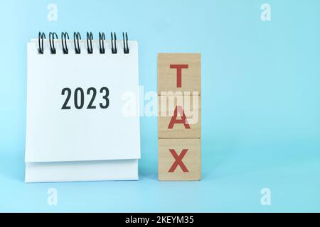Neues Jahr 2023 Steuergeschäft und Rechnungswesen Konzept. 2023 Tischkalender mit Holzblöcken und Wortsteuer. Stockfoto