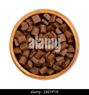 Schokoladenstückchen in einer Holzschale. Chips und kleine Häppchen aus Milchschokolade, die als Zutat in einer Reihe von süßen Desserts verwendet werden. Stockfoto