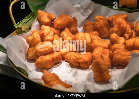 Gebratener traditioneller Thai-Teig oder Pa Tong Ko in thailändischer Sprache, gebratener Teig bereit zum Servieren, warmes Licht von oben. Stockfoto