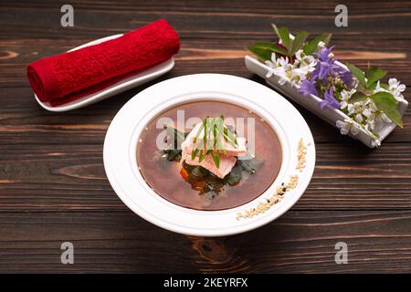 Miso-Suppe mit Lachsfisch auf Holzboden mit Entourage Stockfoto