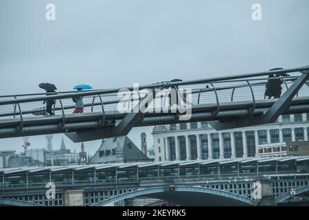 London uk 15 November 2022 Eine Person mit einem blauen Regenschirm, die an diesem nassen Morgen die Milleniumbrücke überquert.Paul Quezada-Neiman/Alamy Live News Stockfoto