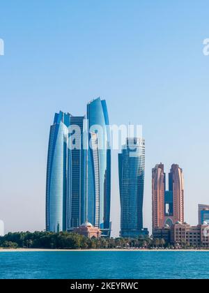 Business Area in Downtown Abu Dhabi, Vereinigte Arabische Emirate an einem sonnigen Nachmittag - aufgenommen über das Wasser Stockfoto