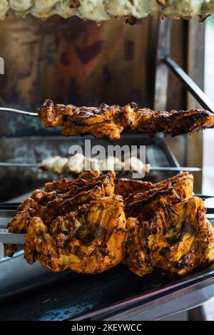 Kochen Hähnchenschief Kebab Grill. Traditionelles indisches und paksitanisches Gericht, gekocht auf Holzkohle und Flamme. Stockfoto