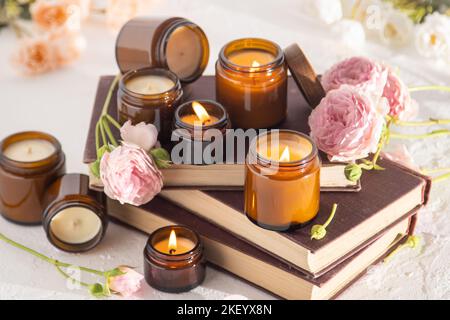 Ein Set verschiedener Duftkerzen in braunen Glasgefäßen. Handgemachte Duftkerze. Sojalkerzen brennen in einem Glas. Aromatherapie und entspannen Sie sich im Spa und zu Hause. Feuer in braunem Glas. Stockfoto