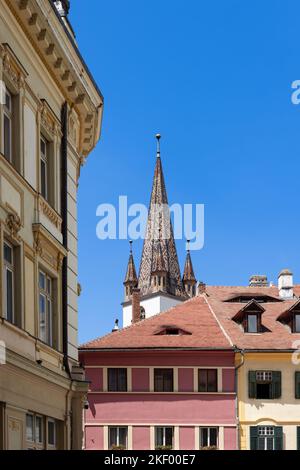 Vertikale Foto von bunten Kirchturm der lutherischen Kathedrale der Heiligen Maria (Biserica Evanghelica), und ikonische Augenbrauen dormers der Augen von Sibiu sind sichtbar Stockfoto