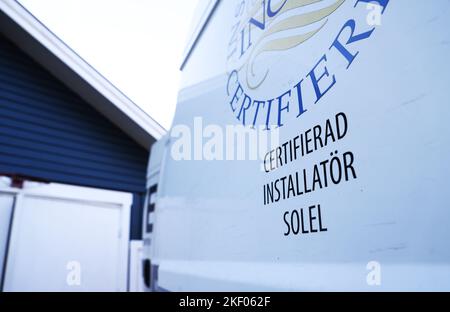 Ein Handwerker, der Sonnenkollektoren auf einem Haus installiert. Stockfoto