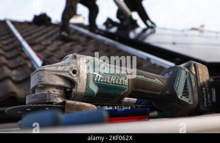 Ein Handwerker, der Sonnenkollektoren auf einem Haus installiert. Stockfoto