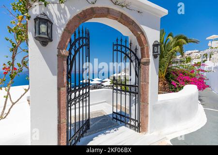 Eingang einer typischen weißen zykladischen Architektur, Haus mit blauer Tür und blühender rosa Bougainvillea-Pflanze Santorini Insel Griechenland. Inspiration Stockfoto