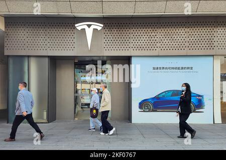 SHANGHAI, CHINA - 15. NOVEMBER 2022 - Fußgänger kommen an einem Tesla-Geschäft in Shanghai, China, vorbei, 15. November 2022. Stockfoto