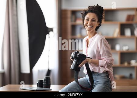 Stilvolle, kreative junge Fotografin mit Kamera in Innenräumen Stockfoto