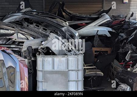 Stapel von Autoteilen aus Metallschrott. Alte, nutzlose, verschlissene, gebrochene Metall- und Plastikteile in der Nähe des Reparaturdienstes Stockfoto
