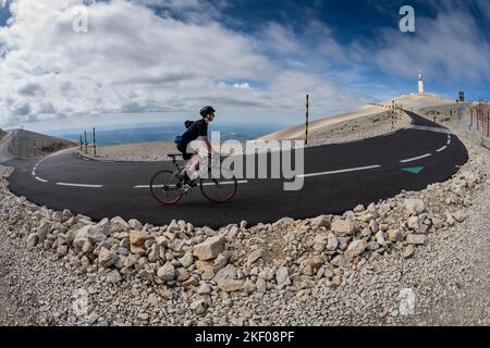 Ein männlicher Radler klettert durch eine Haarnadelkurve im letzten Kilometer des Mont Ventoux, Provence, Frankreich. Stockfoto