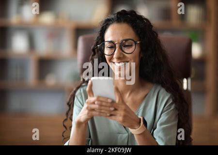 Glücklich attraktive Frau trägt Brillen mit Handy Stockfoto