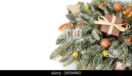 Weihnachtliche Bordüre mit Tannenzweigen, Geschenken und festlichem Dekor auf weißem Hintergrund. Fichte nobilis. Komposition zum neuen Jahr. Speicherplatz kopieren. Stockfoto