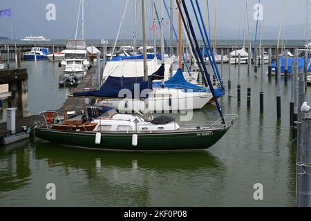 Segelyachten in Reihen in einem Yachthafen, teilweise überdacht für die Wintersaison und mit abgesenkten Segeln. Stockfoto