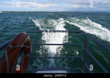 Schaumspuren im Wasser hinter dem Touristen- und Passagier-Katamaran, der durch den Bodensee segelt. Stockfoto