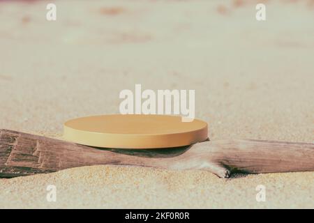 Leeres rundes beiges Podium und trockener Baumzweig am Strand Stockfoto