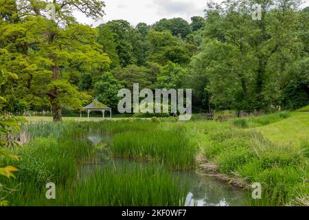 Blick auf den wunderschönen Metallbandständer mit Blumen in einem hübschen englischen Landgarten Stockfoto