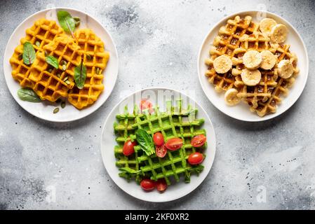 Verschiedene belgische Waffeln auf grauem Hintergrund Stockfoto