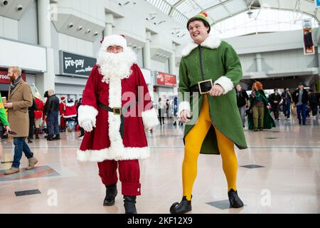 BIRMINGHAM NEC, GROSSBRITANNIEN – 13. NOVEMBER 2022. Ein Paar männlicher Cosplayer, gekleidet als Buddy the Elf und Santa Claus, auf der MCM Birmingham Comic Con 2022 Stockfoto