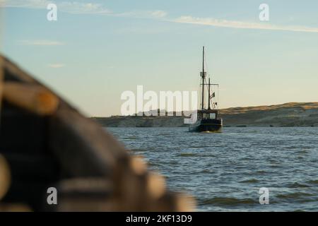 Piratenschiff segelt bei Sonnenuntergang im Meer. Holzboot, das im Urlaub fährt. Stockfoto