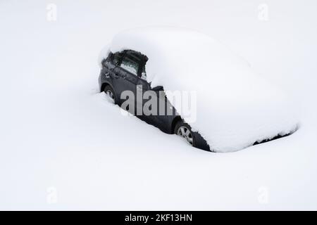 Auto mit dicken Schneeschichten bedeckt. Auto nach Schneesturm auf der Straßenseite geparkt. Stockfoto