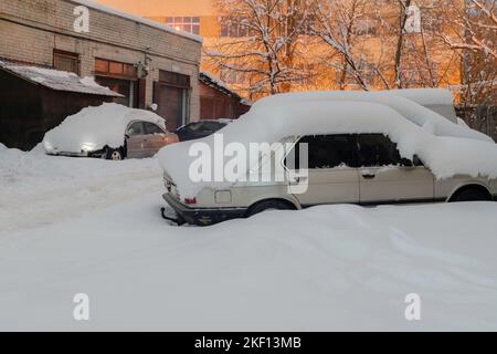 Auto mit dicken Schneeschichten bedeckt. Auto nach Schneesturm auf der Straßenseite geparkt. Stockfoto