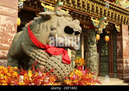 Chinesische männliche Schutzlöwenskulptur vor einem chinesischen buddhistischen Schrein Stockfoto