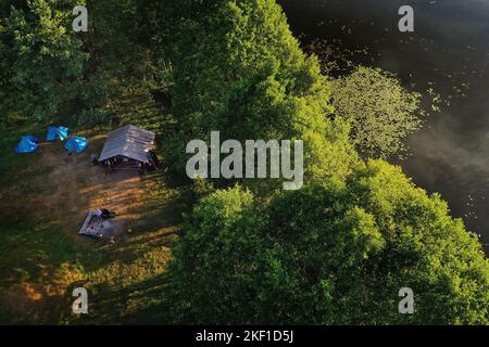 Blick von oben auf die Touristenbasis und den Bolta-See im Wald im Nationalpark Braslav-Seen bei Sonnenaufgang, den schönsten Orten der Stadt Weißrussland Stockfoto