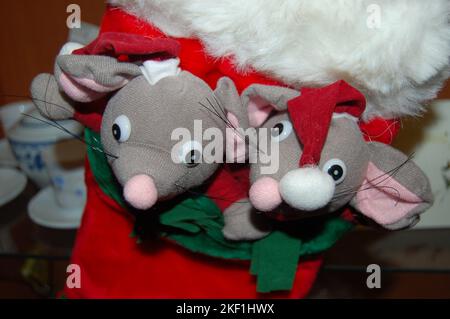 Zwei ausgestopfte Mäuse tragen einen roten Weihnachtshut mit einer weißen Kugel oben und innen einen roten Stiefel mit weißem Pelzbesatz Stockfoto