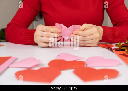 Herstellung Origami Herzen für Valentinstag. Basteln aus Papier mit eigenen Händen. Stockfoto