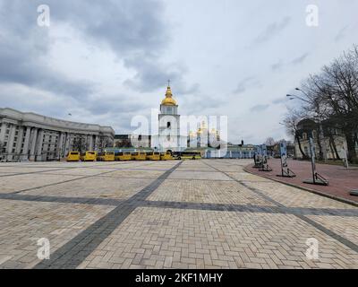 Die gelben Busse parkten während der russischen Invasion auf dem leeren Michaelsplatz. Kiew, Ukraine. Stockfoto