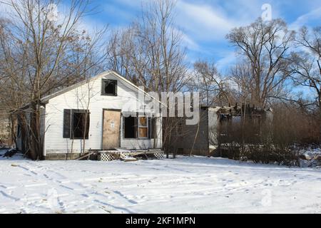 Zwei verlassene Häuser in Brightmoor, eines davon in einem Brandschaden, im Winter in Detroit Stockfoto