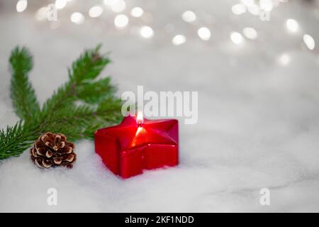 Rote Kerze mit Tannenzweigen mit Tannenzapfen, Weihnachtskarte mit Kopierraum Stockfoto
